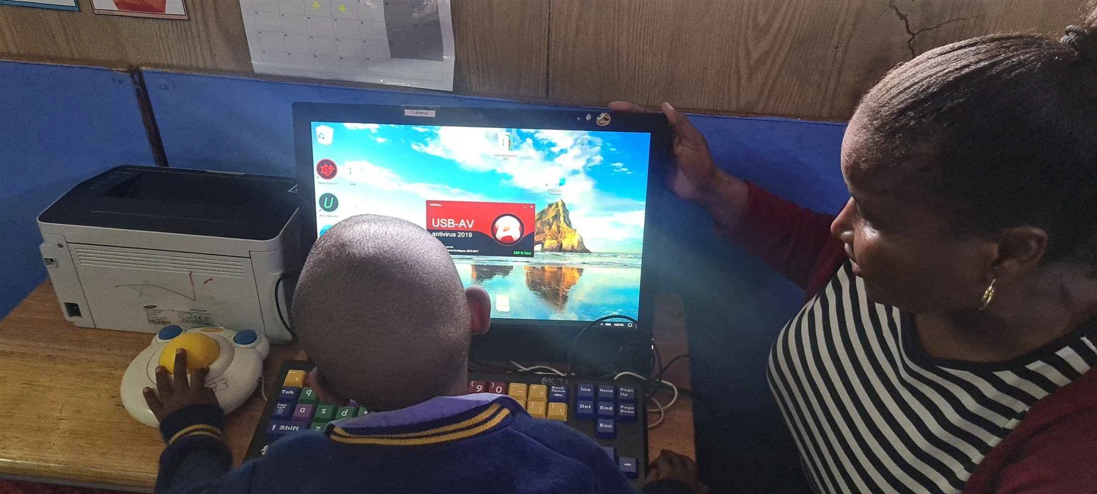 A learner and educator using a computer.